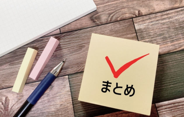 まとめとチェックマークが書いてあり、その周りにはシャーペンと付箋、ノートが置いてある写真
